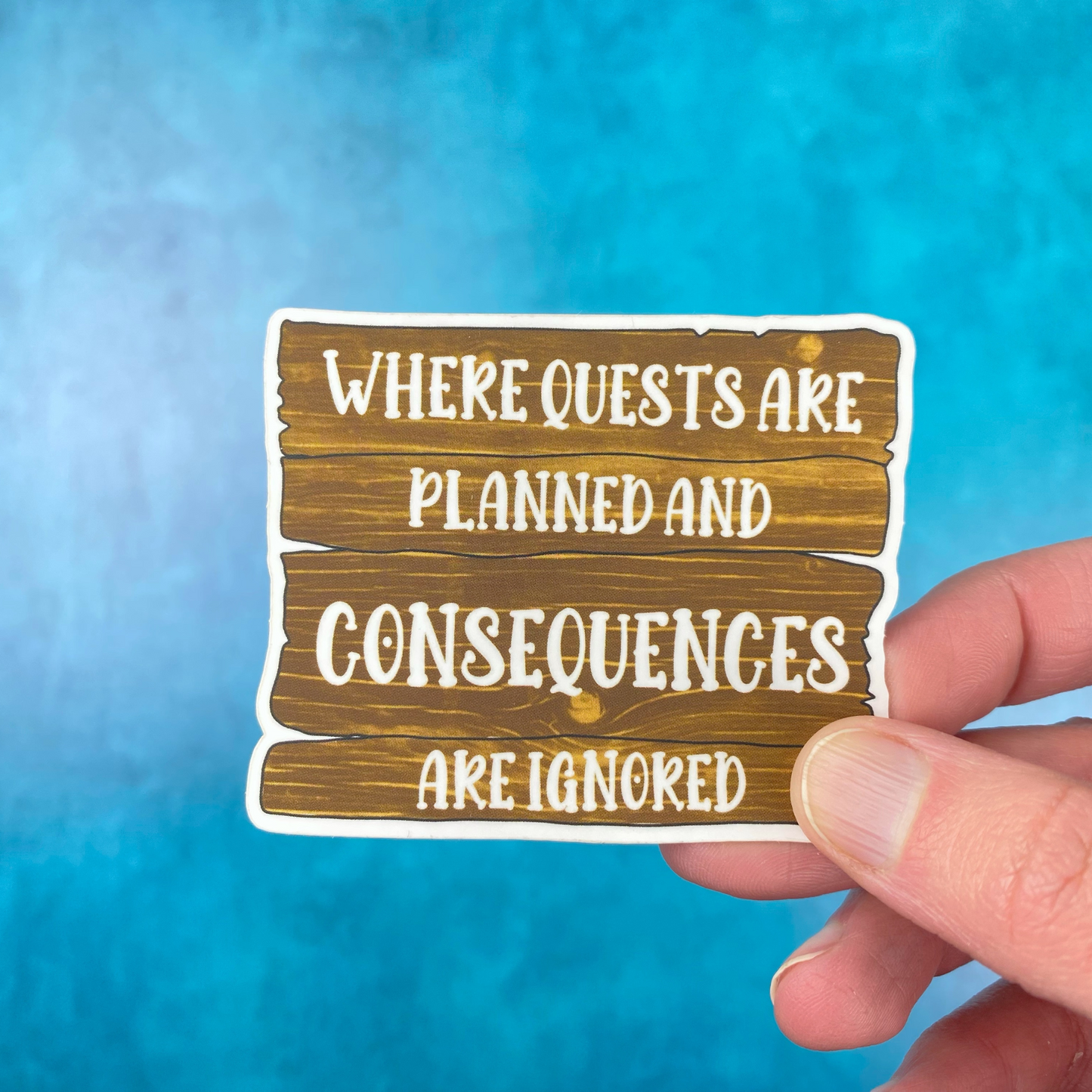 Die-cut vinyl sticker showing a weathered wooden sign with the text "Where quests are planned and consequences are ignored," on a teal background