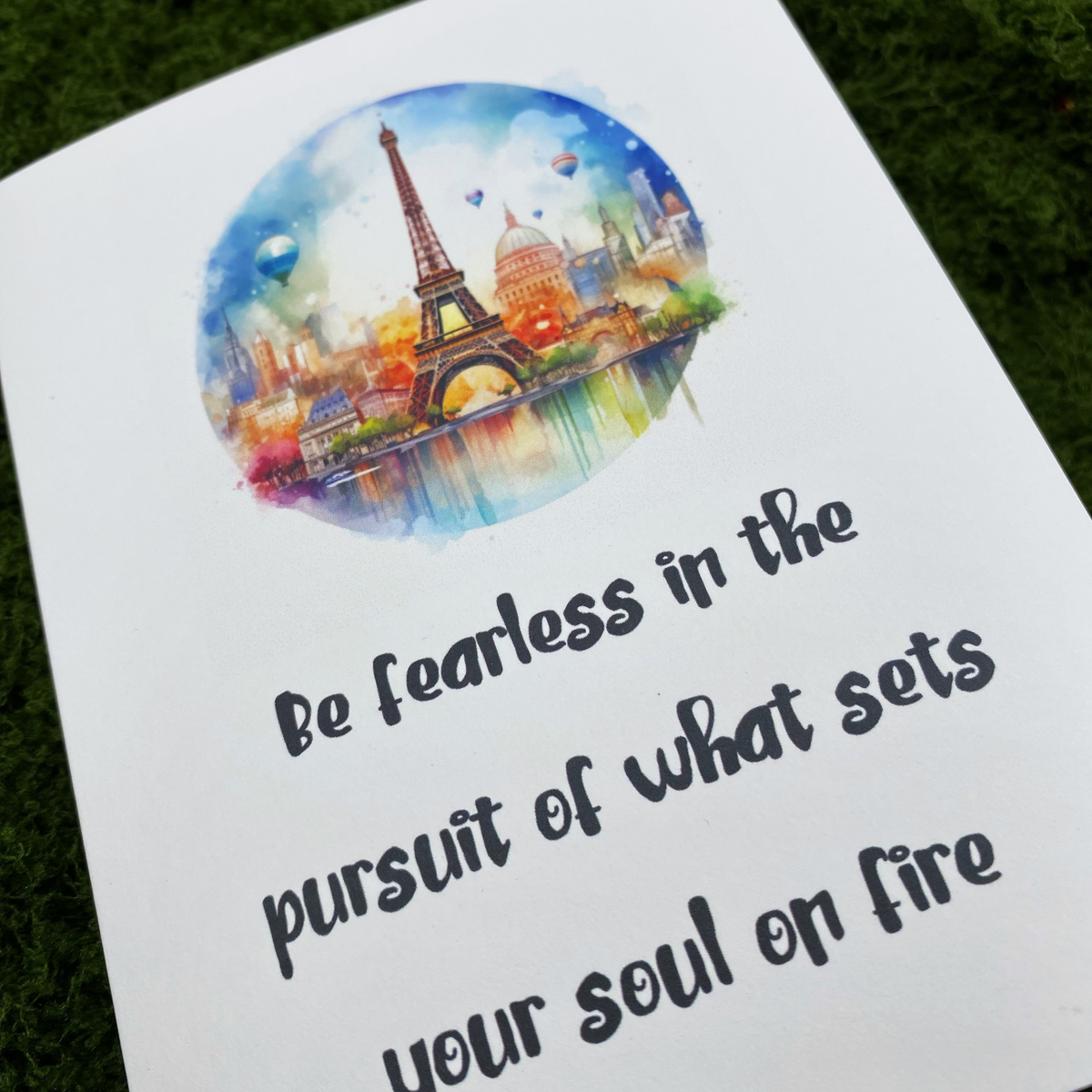 Close-up of the card's cover showing a watercolor illustration of the Eiffel Tower, Paris rooftops, and hot air balloons in a circular frame, above the handwritten-style text "Be fearless in the pursuit of what sets your soul on fire."