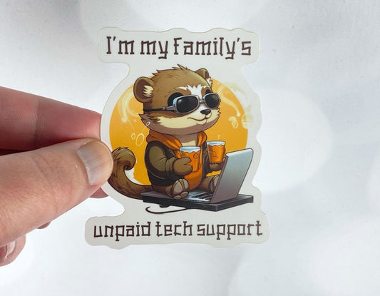 A hand holds a sticker illustration of a otter wearing goggles and holding two drinks while sitting at a laptop, reading "I'm my family's unpaid tech support," against a white background.