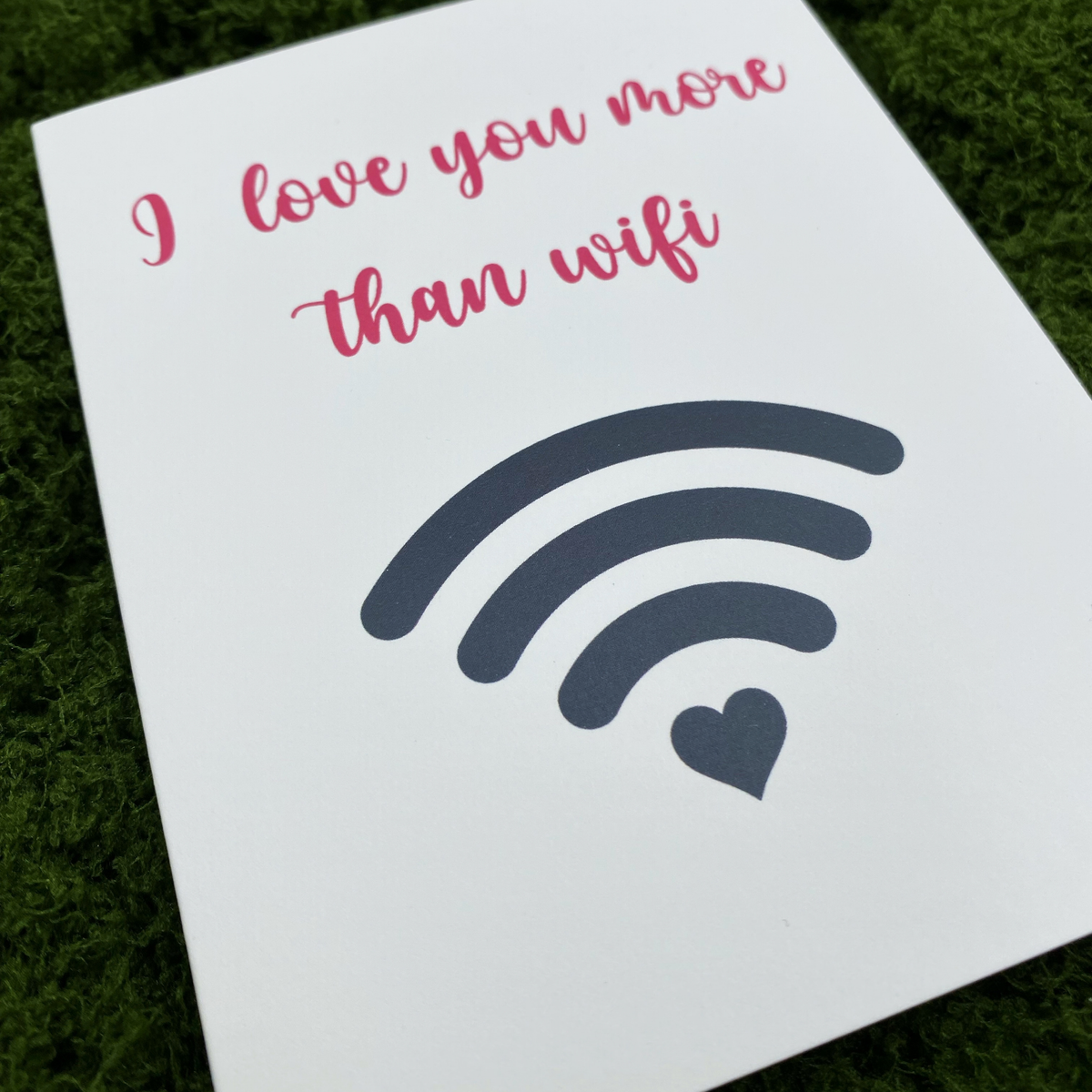 Close-up of the card's cover design showing "I love you more than wifi" in pink cursive text above a dark gray wifi symbol with a heart as its bottom signal bar.