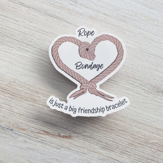 Die-cut vinyl sticker featuring a rope tied into a heart shape with the text "Rope Bondage is just a big friendship bracelet"