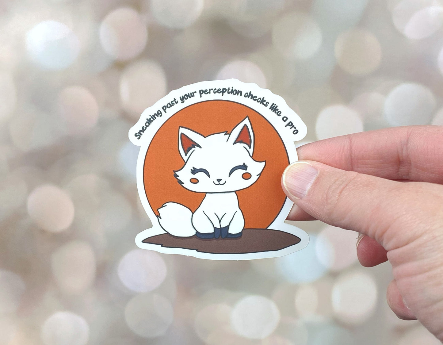 Die-cut vinyl sticker showing a white fox sitting in front of an orange circle, with the text "Sneaking past your perception checks like a pro," on a golden bokeh background